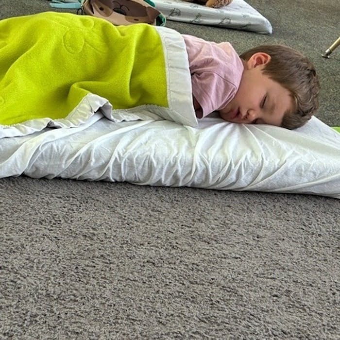 Img: blanket, person, sleeping, bed, furniture, helmet