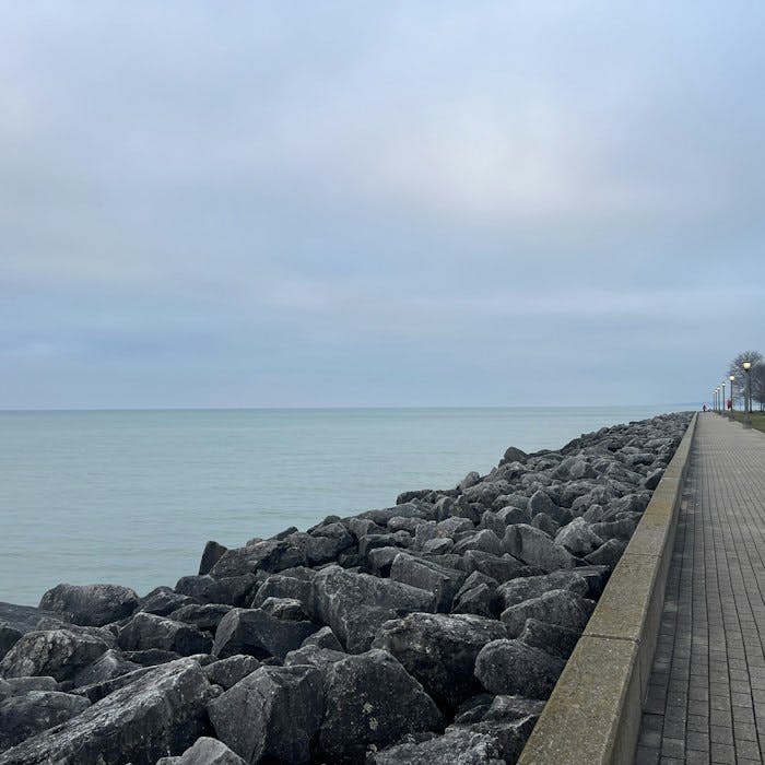Img: path, walkway, water, waterfront, rubble, person, road